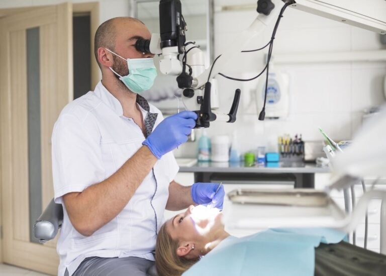 Dentista realizando una endodoncia con microscopio a una paciente