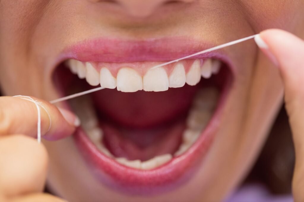Paciente usando hilo dental como parte de su higiene diaria