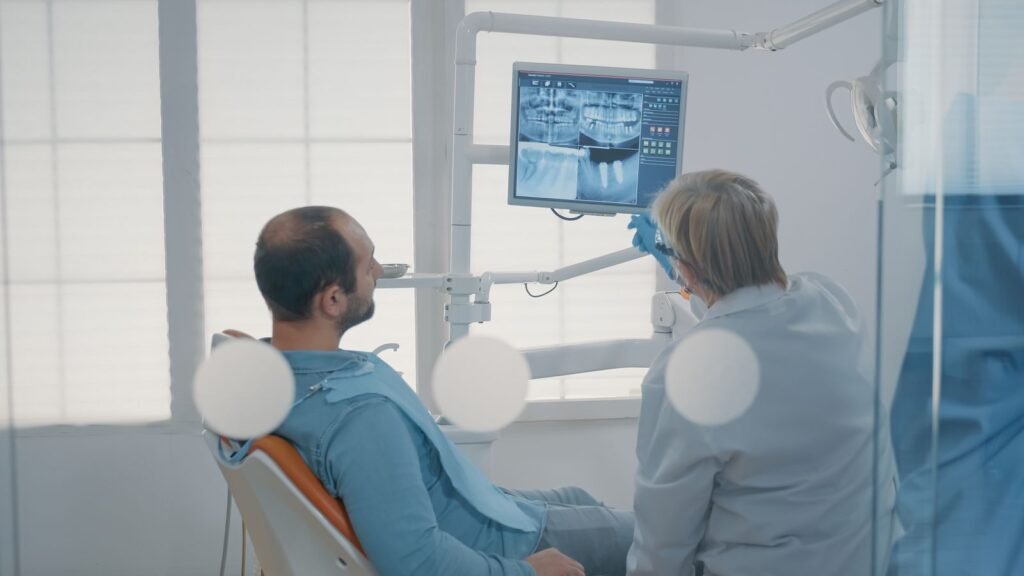 Dentista mostrando una radiografía dental a un paciente con dolor de muelas
